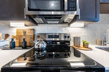 a kitchen with a stove and a microwave at The Monroe Apartments, Austin, Texas